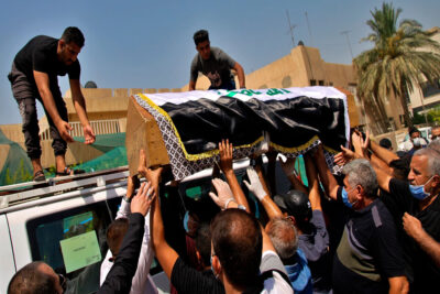 ته‌رمى هیشام هاشمى له‌كاتى به‌ڕێكردنى بۆ گۆڕستان | فۆتۆ: Khalid Mohamed / Associated Press